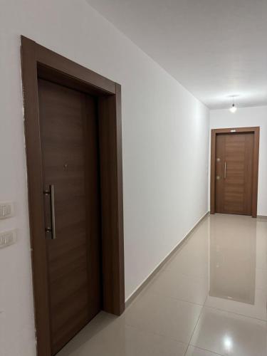 an empty hallway with two doors in a building at Holiday season at sea in Shëngjin