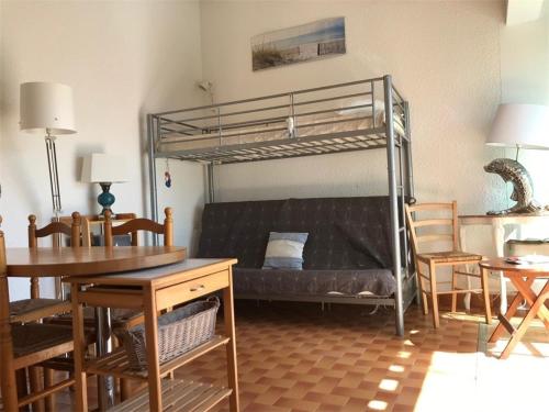 - un salon avec des lits superposés, une table et des chaises dans l'établissement Charmante Maison 4 pers, Terrasse, Parking Privé, Proche Plage - Port Leucate - FR-1-81-123, à Port-Leucate