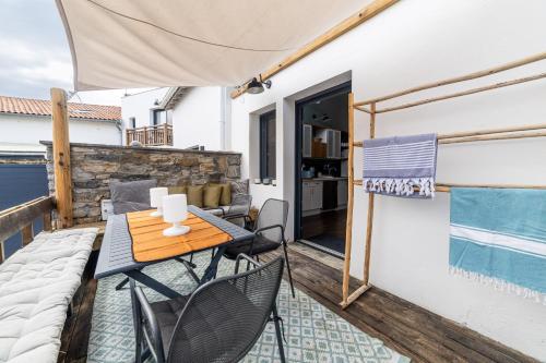 un patio avec une table et des chaises sur un balcon dans l'établissement Biarritz Surf Appartements 300m de la plage, à Biarritz
