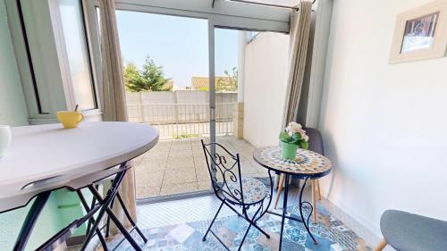 Cette chambre dispose d'une table, de chaises et d'un balcon. dans l'établissement La Corniche d Or, à Les Bussolleries