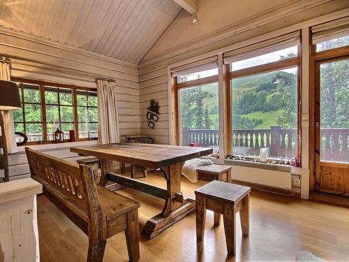 une salle à manger avec une table, des bancs et des fenêtres dans l'établissement Chalet spacieux 15 pers avec sauna et jacuzzi, proche pistes - Plagne 1800 - FR-1-455-159, à La Plagne