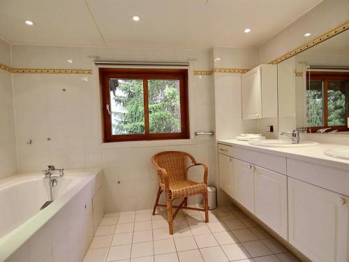 La salle de bains est pourvue d'une chaise, d'une baignoire et d'un lavabo. dans l'établissement Chalet spacieux 15 pers avec sauna et jacuzzi, proche pistes - Plagne 1800 - FR-1-455-159, à La Plagne