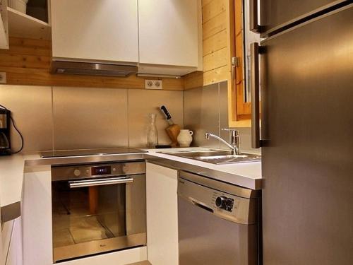 une cuisine avec un réfrigérateur en acier inoxydable et un évier dans l'établissement Chalet rénové pour 10 avec jacuzzi, cheminée et WiFi aux pieds des pistes - FR-1-455-155, à La Plagne