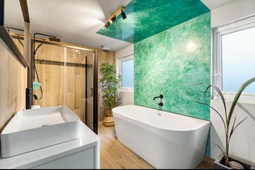a bathroom with a white tub and a green wall at Cozy Dover House with 4 Bedrooms in Dover