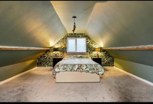 a attic bedroom with a bed and a window at Cozy Dover House with 4 Bedrooms in Dover