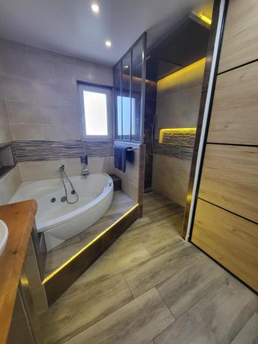 une salle de bain avec une baignoire et un lavabo dans l'établissement 8-person apartment - Chill & beach 5 min away, à Saint-Laurent-de-la-Salanque