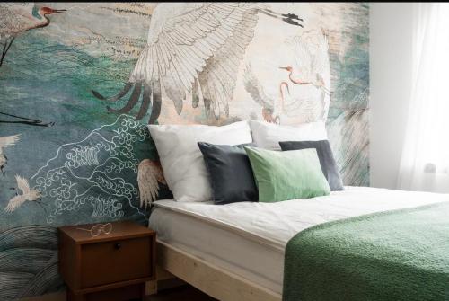a bedroom with a bed with a wallpaper with birds at Chlewiska nad Świnką in Narol