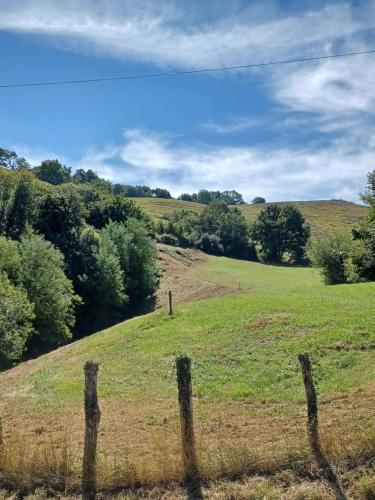 a fence in a field with trees in the background at Gite de charme 3* in Saint-Esteben