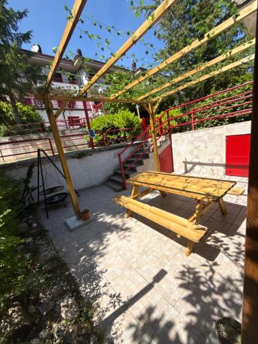 a wooden picnic table and a bench on a patio at Casa serenaurora in Castel di Sangro