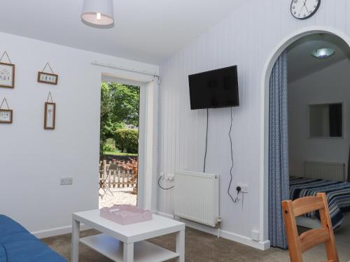 a living room with a blue couch and a table at Little Henford in Beaworthy