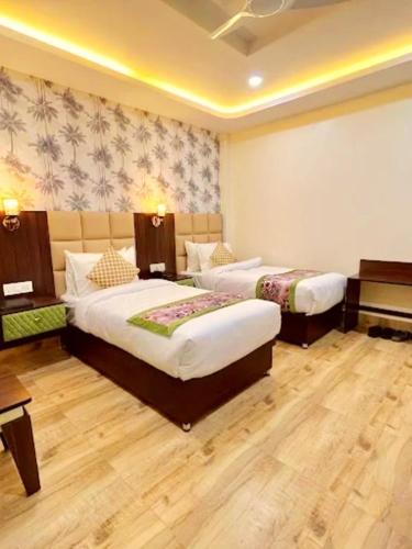 Una habitación de hotel con dos camas y un piano. en Mirror Hotel, en Gangtok