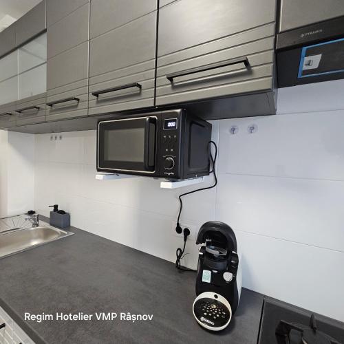 a kitchen with a microwave and a toaster oven at Apartament Rasnov VMP Free parking in Râşnov
