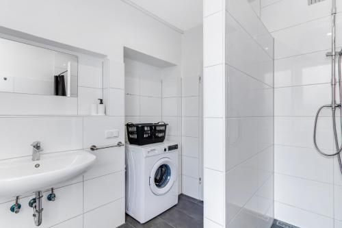 a white bathroom with a washing machine and a sink at BEGE APARTMENTS Corporate Corner in Recklinghausen