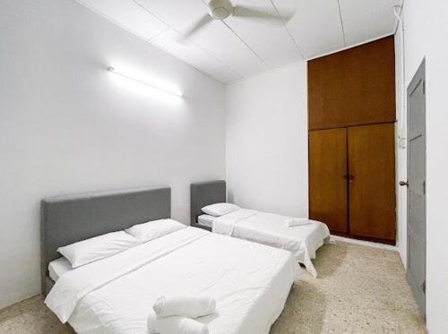 a white room with two beds and a closet at Pearl Cottage - 2min Drive to Lam Wah Ee Hospital in George Town