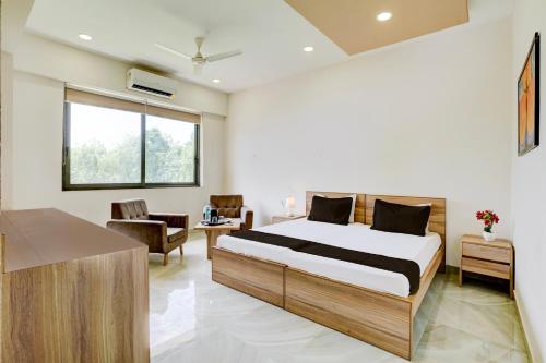 una camera da letto con un letto e un soggiorno di Hotel O SR Farm a Bodakdev