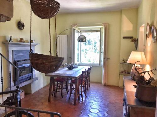 a dining room with a table and chairs and a fireplace at Villa Le Giare in Vignone
