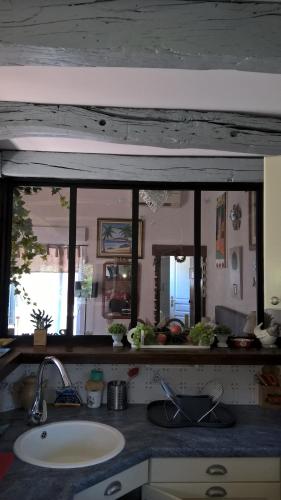 a kitchen counter with a sink and a mirror at Gite de charme 3* in Saint-Esteben