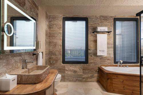 a bathroom with a tub and a sink and a toilet at Barceló Cappadocia in Nevsehir