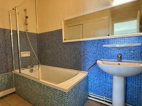 une salle de bain carrelée bleue avec un lavabo et une baignoire dans l'établissement Appartement 2 pièces, 3 couchages, centre-ville, proche mer - FR-1-225-372, à Argelès-sur-Mer