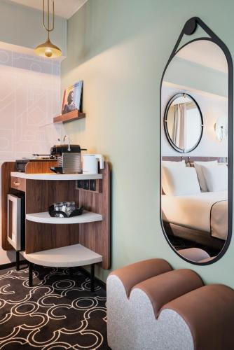 une chambre d'hôtel avec un miroir et un lit dans l'établissement Mercure Paris Opera Grands Boulevards, à Paris