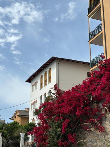 a white building with pink flowers in front of it at Le Finestre Veneris in Portovenere