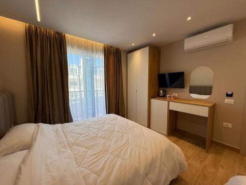a bedroom with a white bed and a mirror at Sevians Apartments in Golem