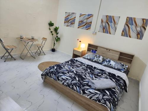 a bedroom with a bed and a table and chairs at Furnished hone stay villa with attached bathroom with balcony in Al 'Ayn