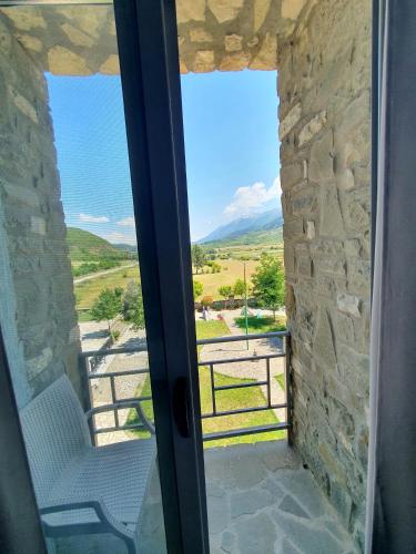 a room with a window with a chair and a view at Kutal Park Inn Hotel in Përmet