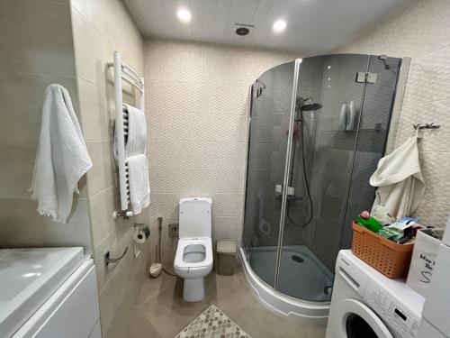 Un baño con ducha, inodoro y lavabo. en Central Luxe 2BR, en Chişinău