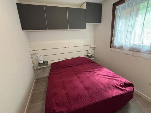 une petite chambre avec un lit avec une couverture rouge dans l'établissement Bel Appartement 2 Pièces au Calme avec Parking et Équipements Complets - FR-1-593-123, aux Angles