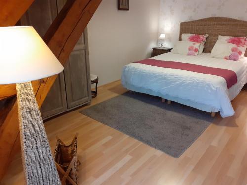 a bedroom with a bed and a lamp at couet et cafe in Seigy