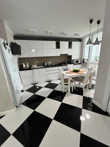 Una cocina con suelo a cuadros en blanco y negro. en Central Luxe 2BR, en Chişinău
