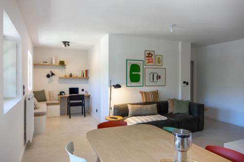un salon avec un canapé et une table dans l'établissement Le Mosaïc - Appartement Design - 2 chambres avec parking privé à Orléans hyper centre, à Orléans