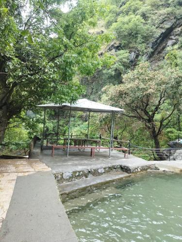 a picnic shelter next to a body of water at Sheetal Restaurant in Mussoorie