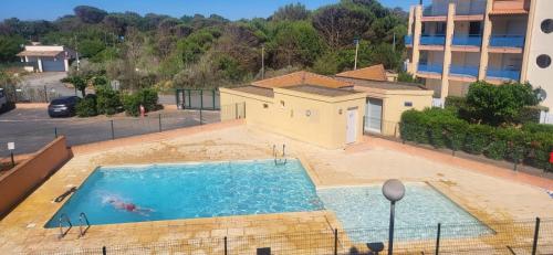 une vue aérienne d'une piscine dans un immeuble dans l'établissement Appartement front de mer et terrasse, à Vias