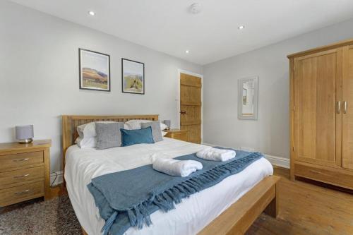 a bedroom with a large bed with two towels on it at Roseberry Cottage in Ambleside