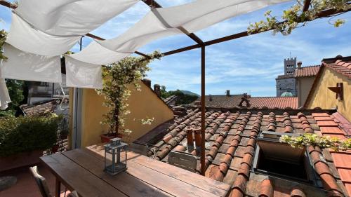 a patio with a table and an umbrella on a roof at La terrazza di Sofia in Lucca