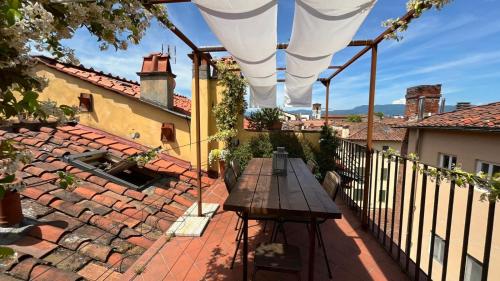 a patio with a wooden table on a roof at La terrazza di Sofia in Lucca