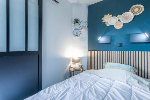 Un dormitorio con una cama y una pared azul. en Appartement Cap Esterel - piscine, en Saint-Raphaël
