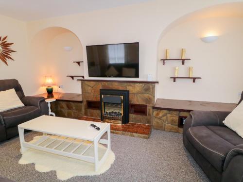 a living room with a fireplace and a tv at 3 Warke Place in Coleraine