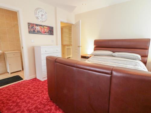 a bedroom with a large bed with a leather headboard at 3 Warke Place in Coleraine