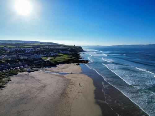 an aerial view of a beach and the ocean at 3 Warke Place in Coleraine