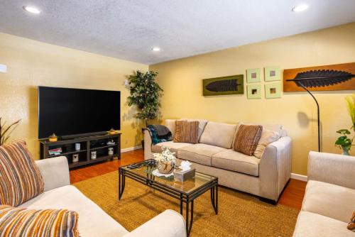 a living room with a couch and a tv at Wine Waves & Comfort 2BR Bay Area Beauty in Hayward