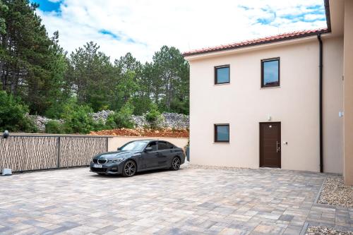 a car parked in a driveway in front of a house at VSG Resort - Apartments 200m from Beach, Pool, Sauna & Jacuzzi in Klimno