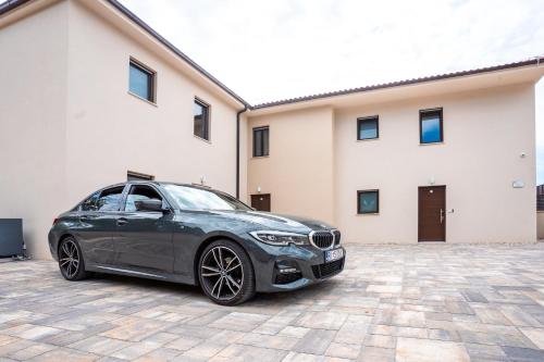 a black car parked in front of a building at VSG Resort - Apartments 200m from Beach, Pool, Sauna & Jacuzzi in Klimno