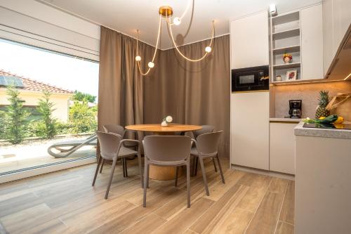 a kitchen and dining room with a table and chairs at VSG Resort - Apartments 200m from Beach, Pool, Sauna & Jacuzzi in Klimno