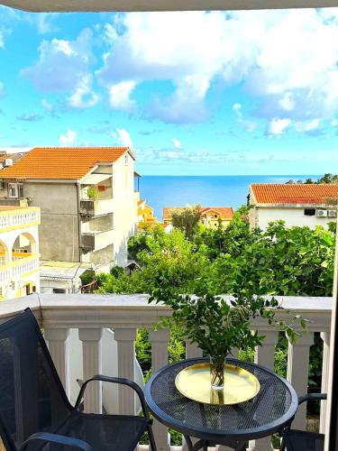a table and chairs on a balcony with a view of the ocean at Cozy apartment with sea view in Petrovac na Moru
