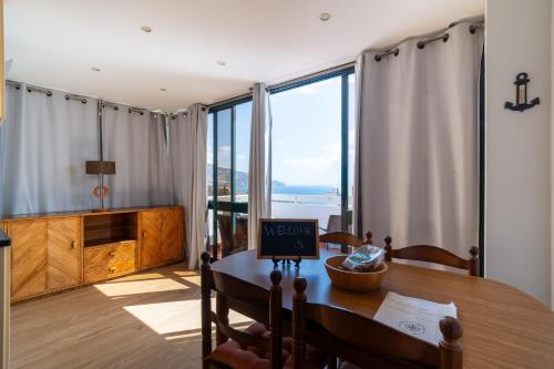 a dining room with a table and a large window at Casa Branca Apartments by Wanderlust Madeira, vacation rentals in Funchal