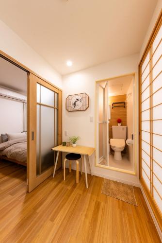 a bathroom with a toilet and a desk in a room at Mars Hotel in Tokyo