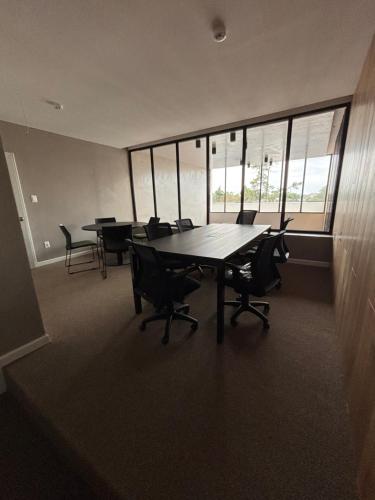 a conference room with a table and chairs and windows at Excepcional Monoambiente edificio LAWA Calyptus in Montevideo